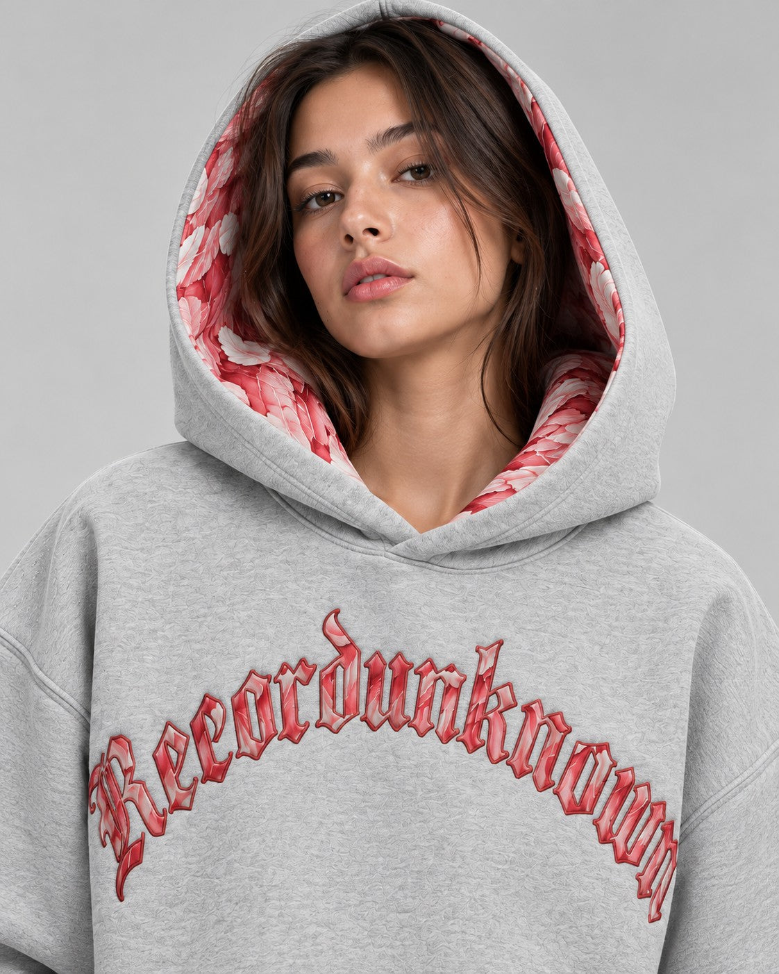 Model wearing the Recordunknown Flamingo Hoodie Grey, hood up showing the flamingo feather lining
