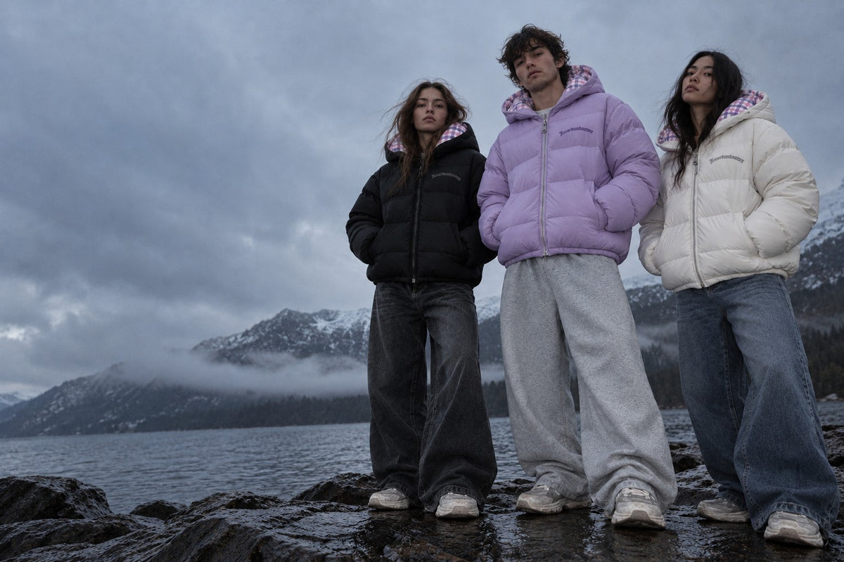 Three models by a mountain lake wearing the Recordunknown black, lilac and ice white puffers