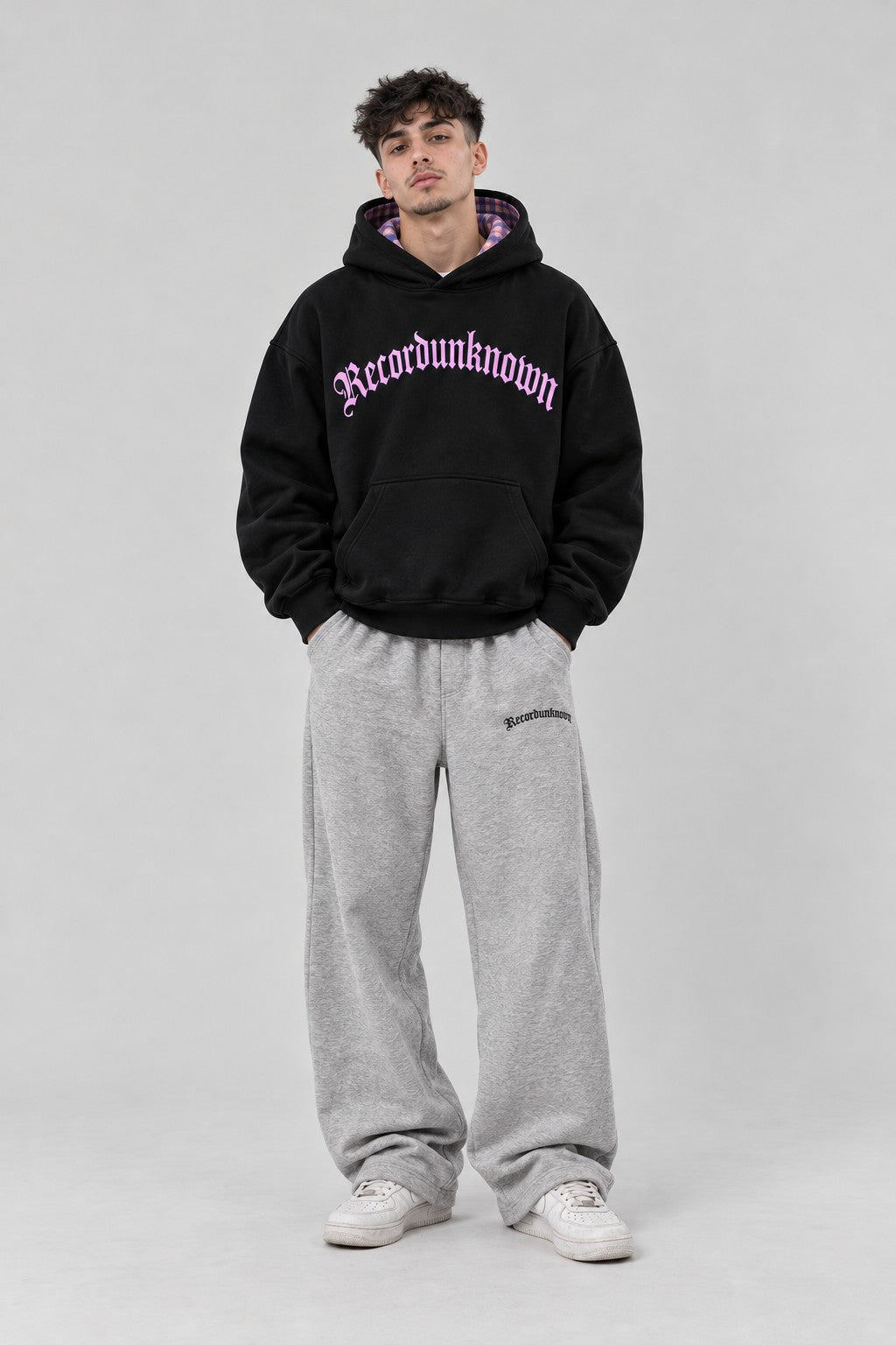Model wearing the Recordunknown black flannel hoodie, full-length studio shot