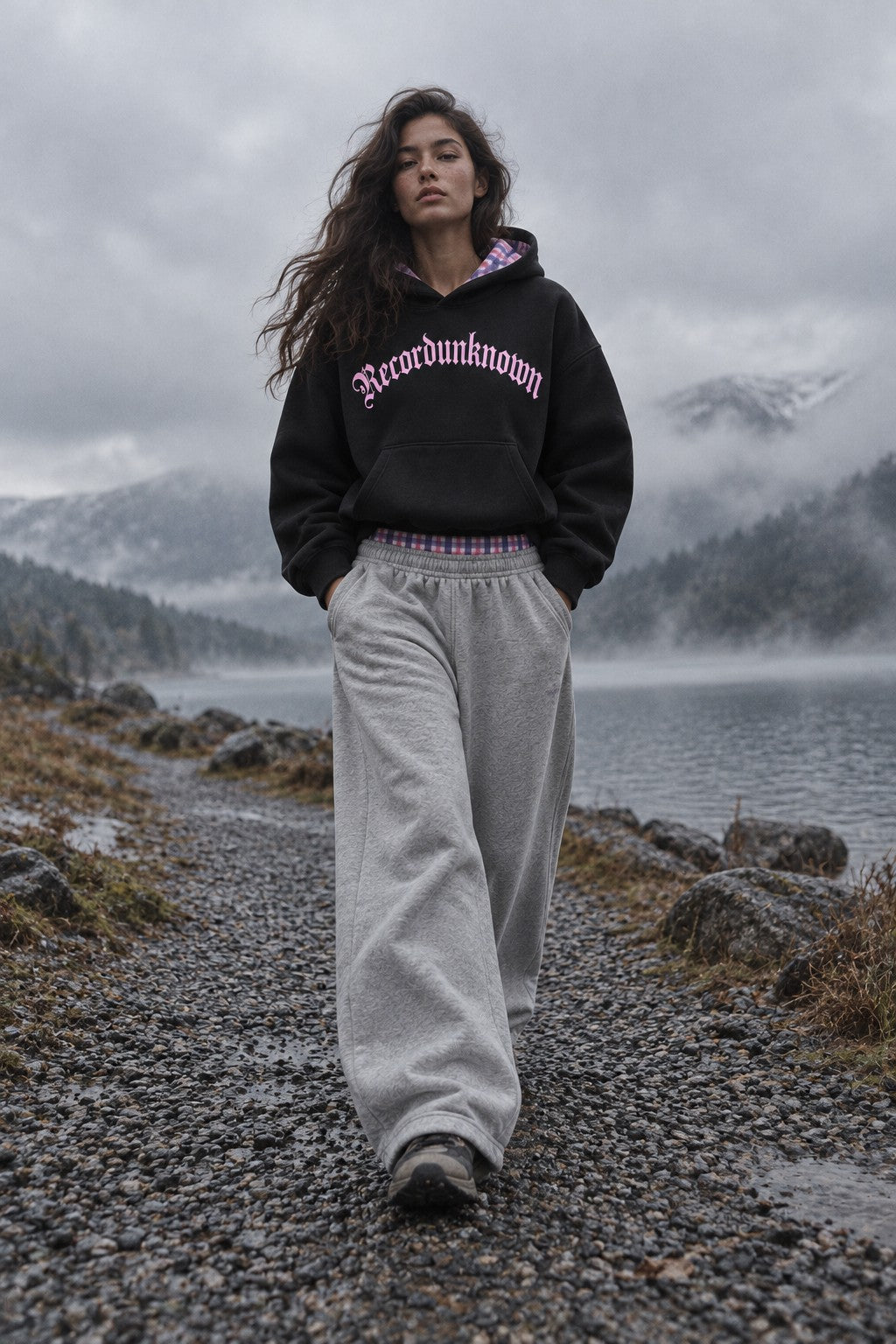 Model by a lake wearing the Recordunknown black flannel hoodie and heather grey flannel sweatpants