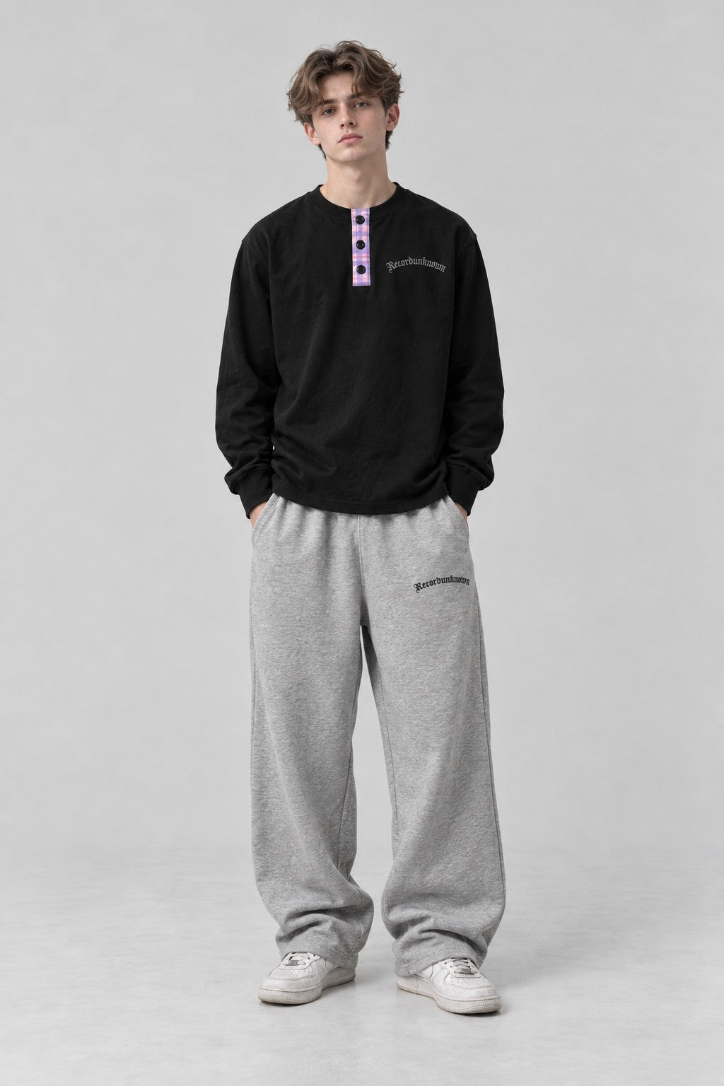 Model wearing the Recordunknown black henley, full-length studio shot