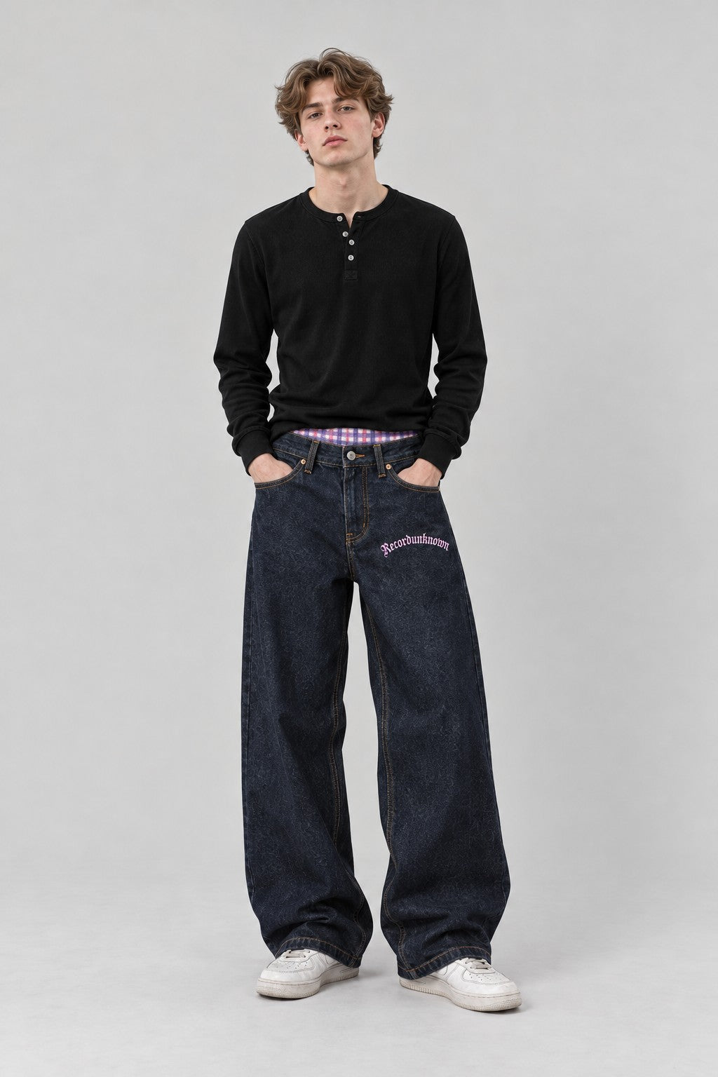 Model wearing the Recordunknown raw denim jeans, full-length studio shot
